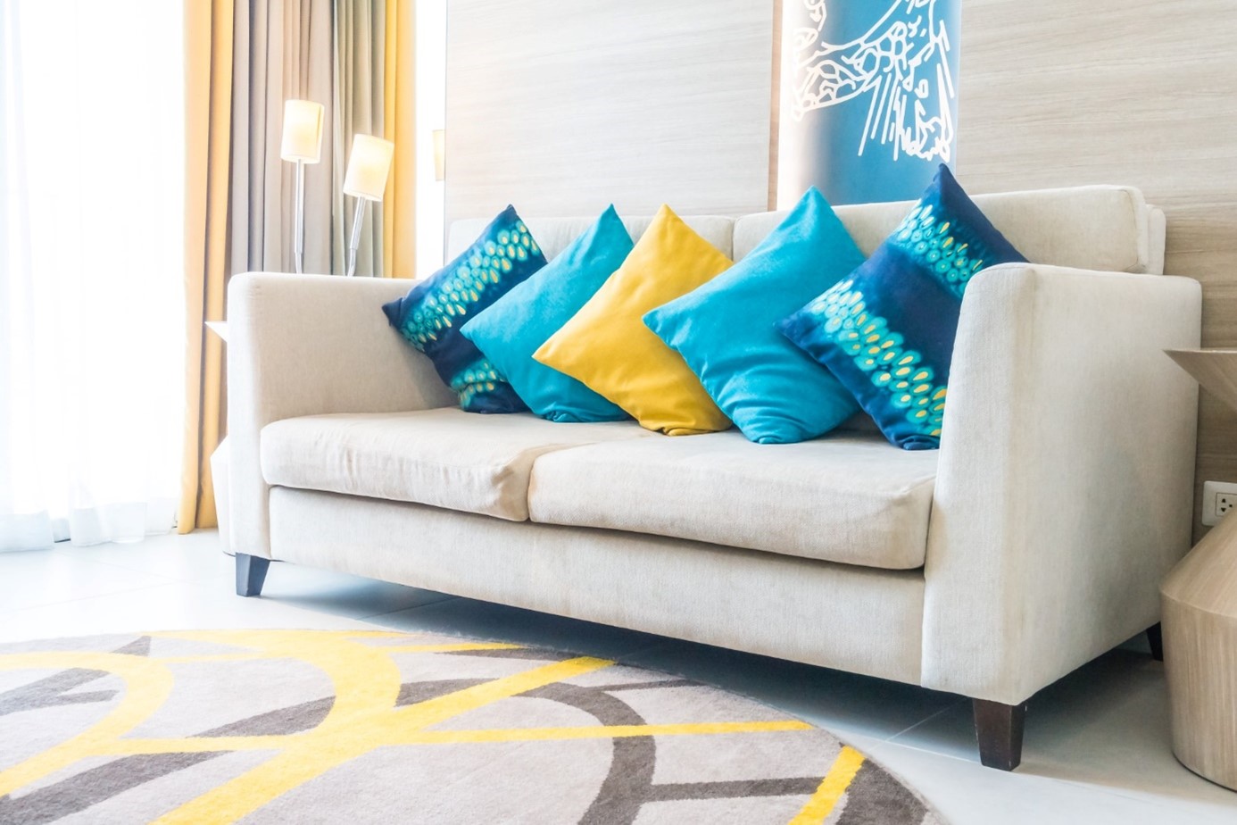 jasna sofa z kolorowymi poduszkami stoi w salonie