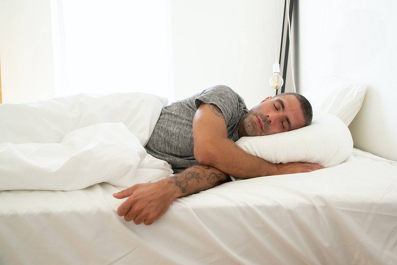 Mężczyzna śpi na pojedynczym łóżku